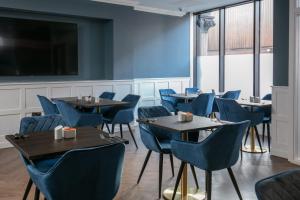 a dining room with tables and chairs and a flat screen tv at Best Western Hotel 99 in Blackburn