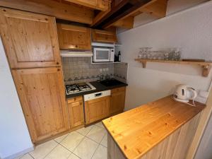 a kitchen with wooden cabinets and a stove top oven at Charmant duplex pied de pistes Briançon in Briançon