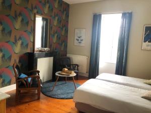um quarto com uma cama, uma mesa e cadeiras em Maison Castel Braz em Pont-Aven