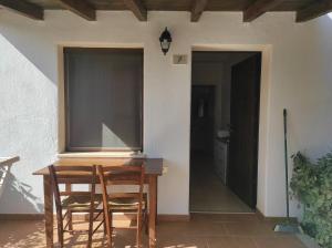 a room with a table and chairs and a window at Sa Teria Village - Camere Deluxe - in Tertenìa
