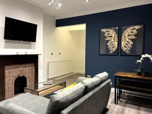 a living room with a couch and a fireplace at Modern Cotham House by Prescott Apartments in Bristol