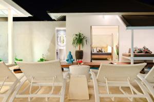- un salon avec des chaises blanches et une table dans l'établissement Villa Dheva, à Seminyak