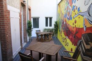 un patio con tavoli, sedie e un murale di Chambre D'hôtes Les Epicuriens a Épernay