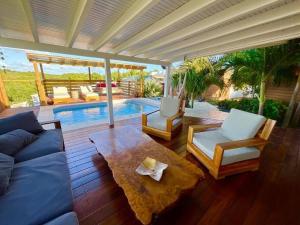 a living room with a couch and chairs and a pool at Villa Titi in Saint-François