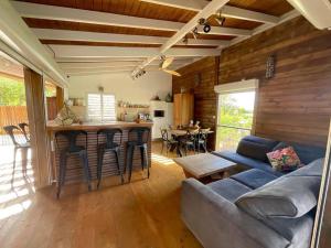 un soggiorno con divano e una cucina con bar di Villa Titi a Saint-François