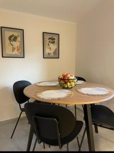 - une table avec des chaises et une corbeille de fruits dans l'établissement Apartament pod Brzozami, à Pławna