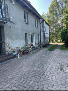 une maison avec une allée en briques à côté d'un bâtiment dans l'établissement Apartament pod Brzozami, à Pławna