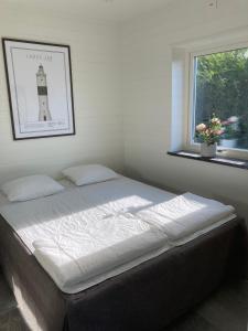 een slaapkamer met een bed met een vuurtorenfoto aan de muur bij Brygghuset, Solviken in Rockneby +37 foto's