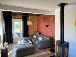 a living room with a couch and a fireplace at Les Logis du Forgeron in Saint-Jean-des-Mauvrets