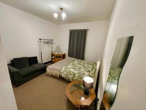 a small bedroom with a bed and a couch at Cathedral view Cottage in Gloucester