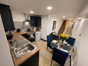 a small kitchen with a sink and a table with chairs at Cathedral view Cottage in Gloucester