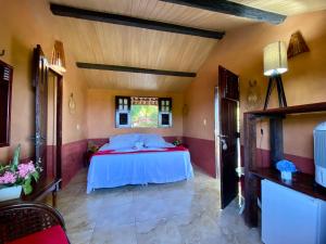een slaapkamer met een bed in een kamer bij Pousada Le Monte Cristo in Guaramiranga