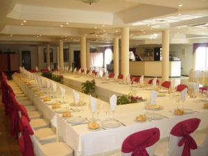 una grande sala banchetti con tavoli bianchi e sedie rosse di Hotel Mitra Crisálida a Cabra