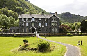 a large black building in a field with a road at The Borrowdale Hotel in Keswick