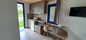 a kitchen with a table and two chairs and a television at Irini Studios in Georgioupolis