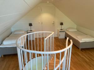 um quarto no sótão com 2 camas e uma escada em Brygghuset, Solviken em Rockneby