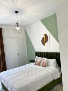 a bedroom with a bed with a green and white wall at Cosy appartement Next to Majorelle Garden in Marrakech
