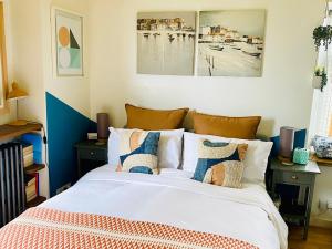 um quarto com uma cama com almofadas em St Ives Balcony Flat em St Ives