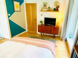 a bedroom with a bed and a television on a table at St Ives Balcony Flat in St Ives