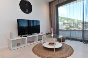 a living room with a tv and a glass table at Villa Bella Vista 2 in Ičići