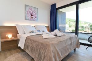 a bedroom with a large bed with a large window at Villa Bella Vista 2 in Ičići