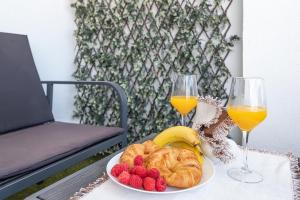 Sunshine Balcony- La Caleta في كاليتا دي فيليز: طاولة مع صحن من الفاكهة وكأسين من عصير البرتقال