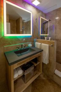 a bathroom with a sink and a mirror at Suites on South Beach in Miami Beach