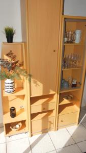 une armoire en bois avec des étagères et une plante. dans l'établissement logement chez Nathalie & Eric, à Mérignac