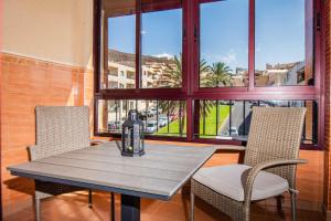 a table and chairs in a room with windows at RELAX JANDIA in Morro del Jable