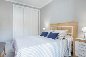 a bedroom with a large bed with blue pillows at RELAX JANDIA in Morro del Jable