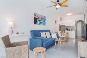 a living room with a blue couch and a kitchen at RELAX JANDIA in Morro del Jable