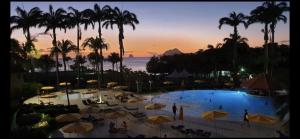 uitzicht op een zwembad met parasols en de oceaan bij Studio Ti Paradise - Magnifique vue mer et diamant in Sainte-Luce