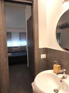 un bagno con lavandino, specchio e letto di Gentile holiday house a Catania
