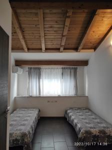 una camera con due letti davanti a una finestra di Gentile holiday house a Catania