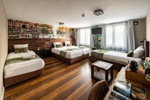 Zimmer mit 3 Betten und einem Tisch in einem Zimmer in der Unterkunft Historic Centre Hotel in Amsterdam