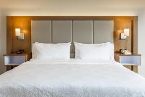 een groot bed in een hotelkamer met witte kussens bij Holiday Inn Express Rockford-Loves Park, an IHG Hotel in Loves Park