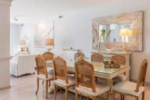 a dining room with a table and chairs and a mirror at Villa Deloxenia by Ethos Hospitality in Mikonos