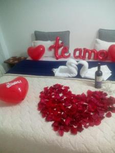 Una cama con corazones rojos y la palabra amnesia en Hostal Villa Rosita en Villa de Leyva