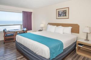 a hotel room with a bed and a desk and a window at Seahorse Oceanfront Lodging in Lincoln City