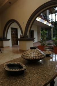 tres jarrones sentados en una mesa en una habitación en Hotel Plaza Yat Balam Anexo, en Copan Ruinas