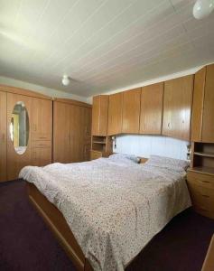 um quarto com uma cama grande e armários de madeira em Wiesbaden Mainz kleines Haus mit Garten Grill em Wiesbaden