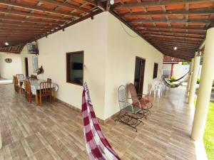 a living room with a porch with a table and chairs at Chácara Paraíso do Rio em Aracaju in Aracaju