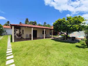 a house with a large yard in front of it at Chácara Paraíso do Rio em Aracaju in Aracaju