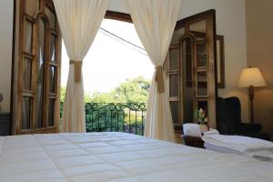 a bedroom with a bed and a large window at Hotel Plaza Yat Balam Anexo in Copán Ruinas