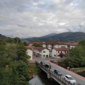 a bridge over a river with cars parked on it at Apartamento Amezti in Elizondo