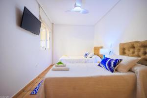 a bedroom with two beds and a flat screen tv at Primera linea de playa , increíbles vistas, amplio in La Mata