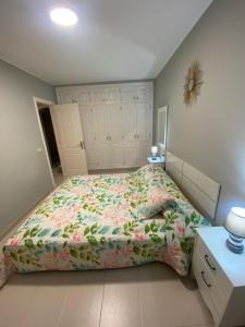 a bedroom with a bed with a floral bedspread at Apartamento en Costa Adeje in Adeje