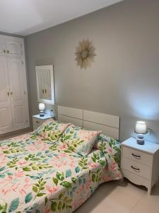 a bedroom with a bed with a floral comforter at Apartamento en Costa Adeje in Adeje