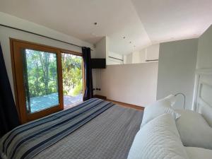 a bedroom with a bed with a large window at Calera de Tango Chena Magica in Maipú