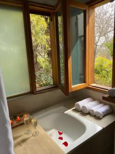 a bathroom with a bath tub with two glasses of wine at Calera de Tango Chena Magica in Maipú